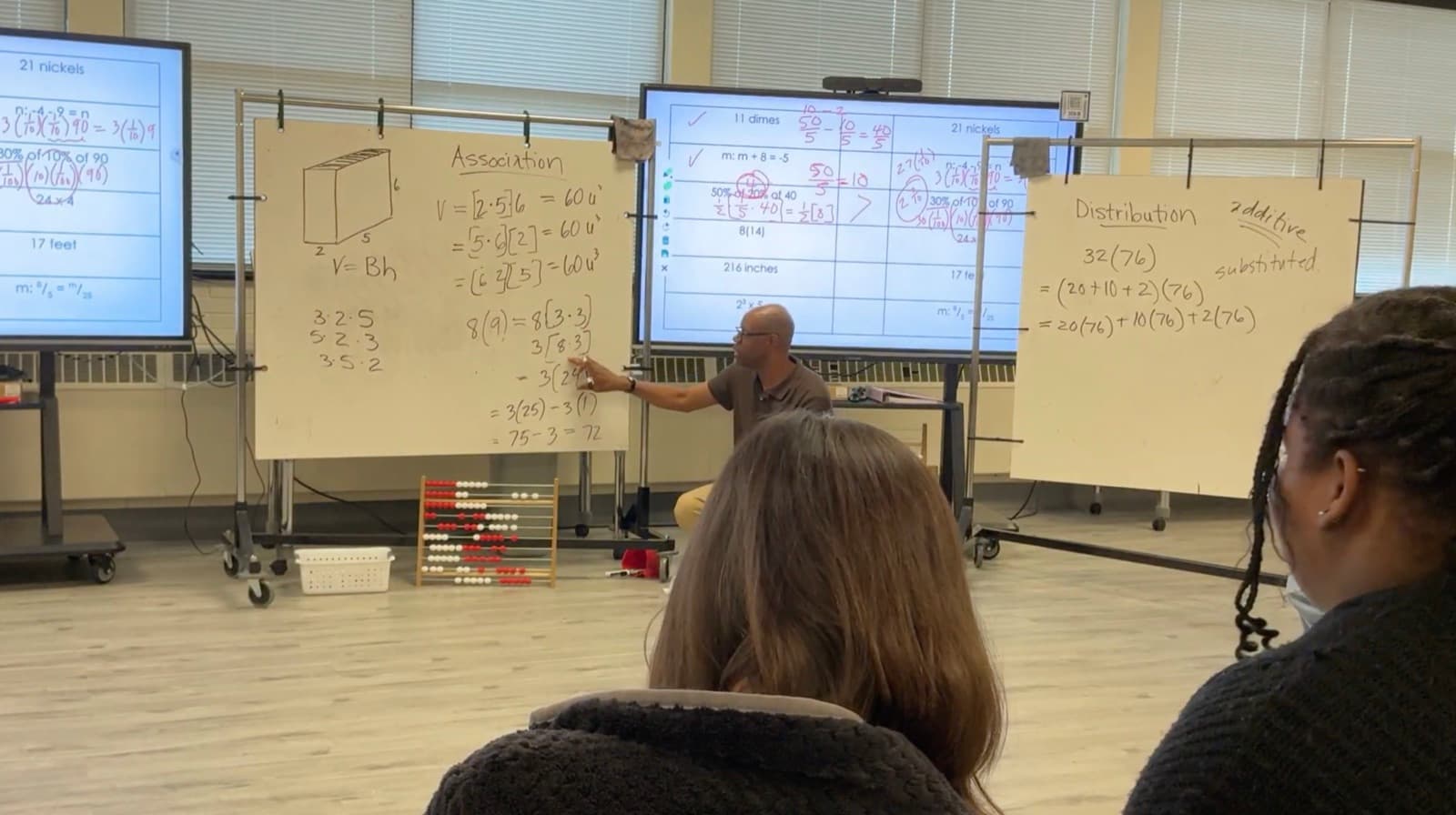 Kevin Moore working an expression through at a whiteboard headed Association, teachers watching from the room.